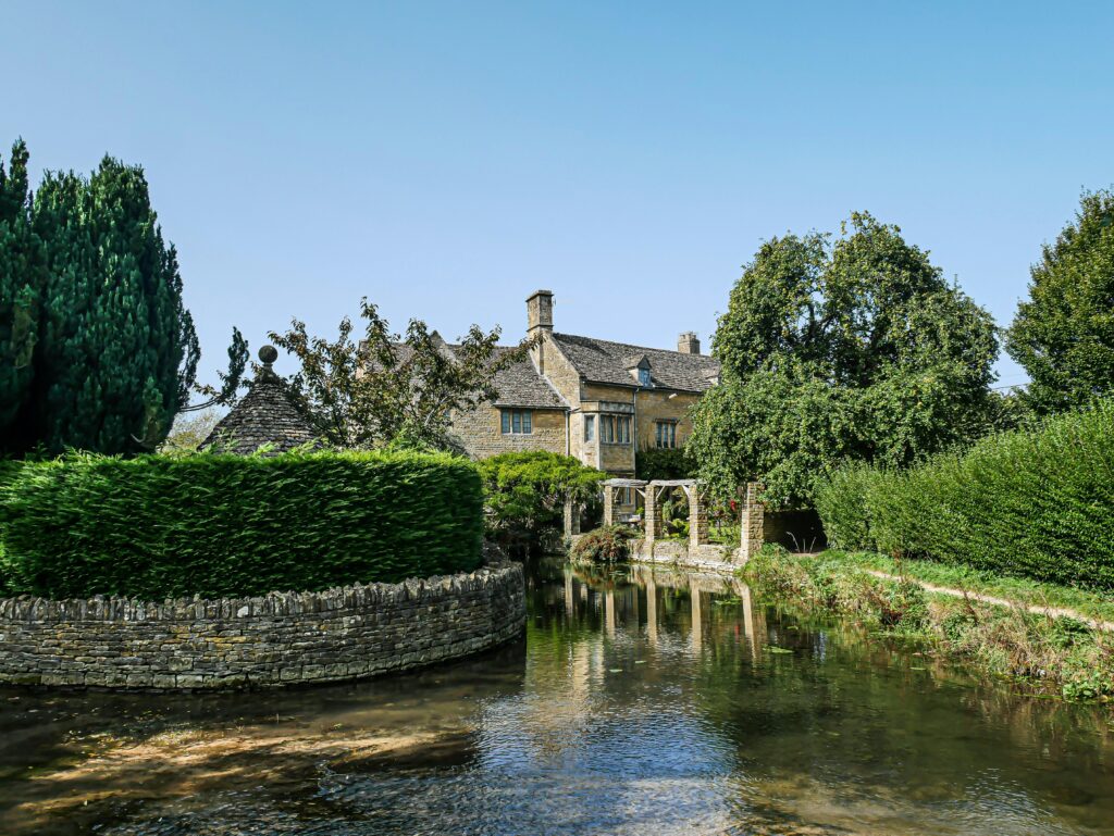 Bourton on the Water in the Cotswolds. brown-concrete-house-near-river-during-daytime